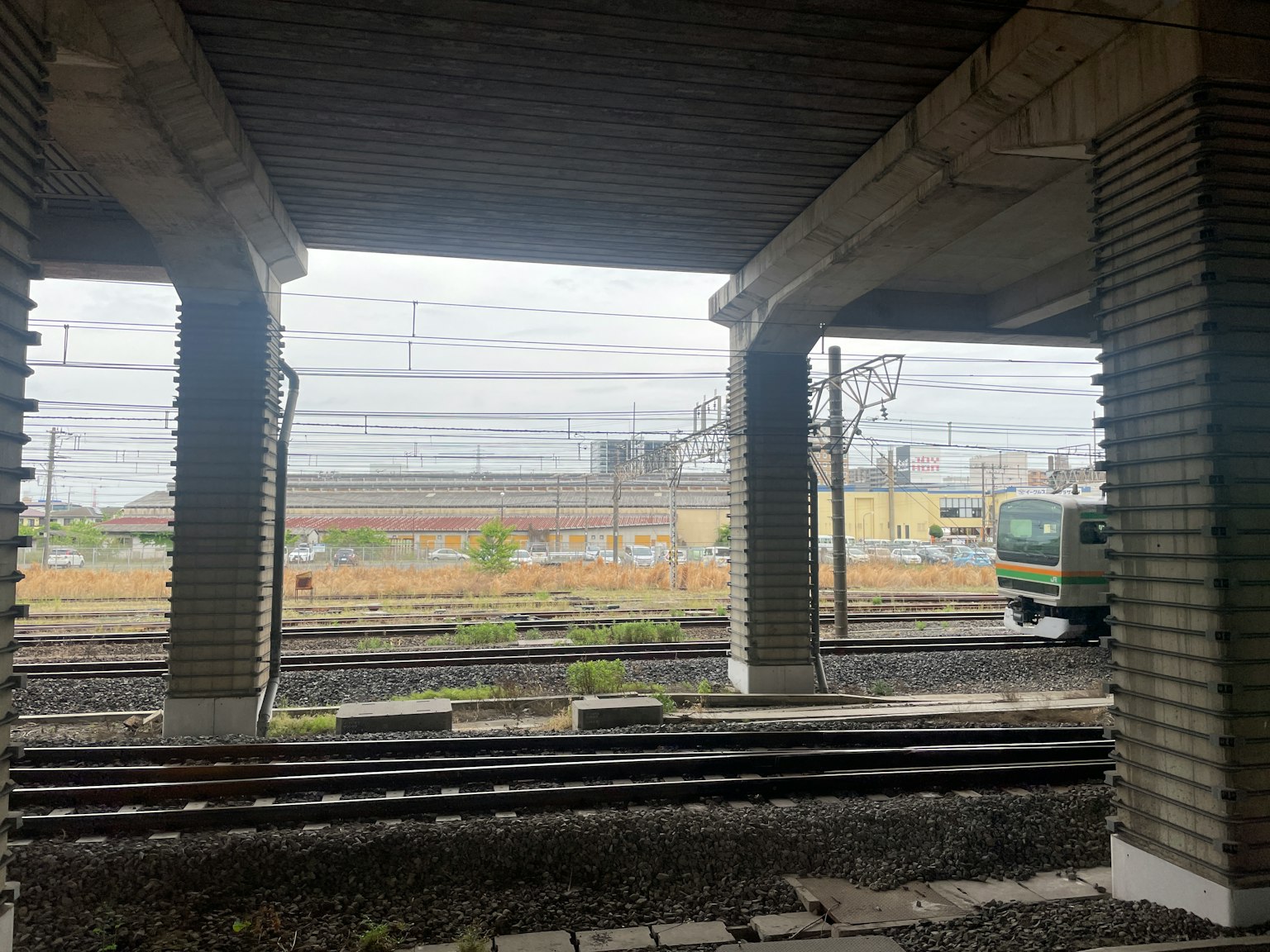 Pemandangan rel kereta dan kereta dari bawah jembatan