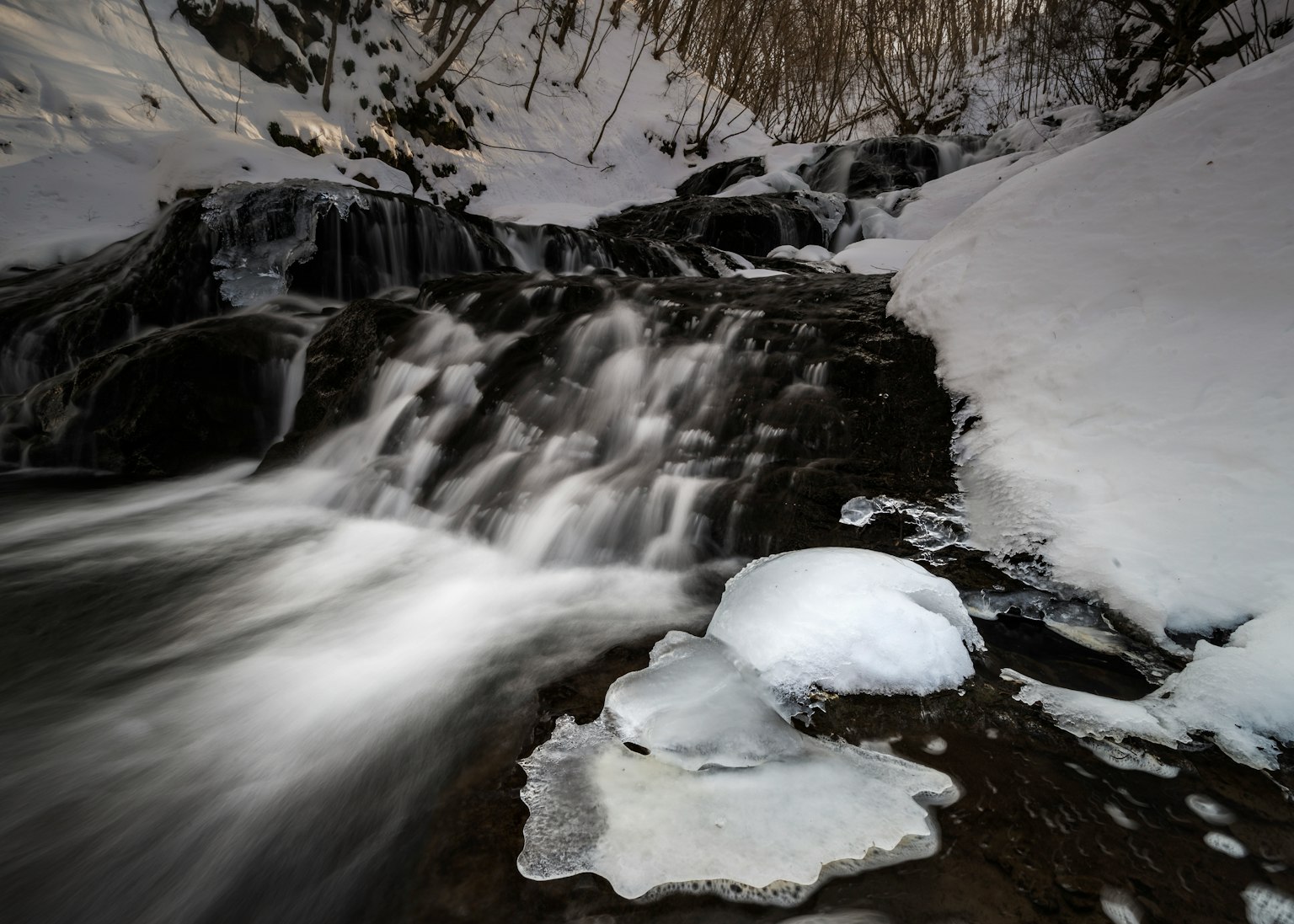 Winterlandschaft mit einem fließenden Fluss und Eisformationen
