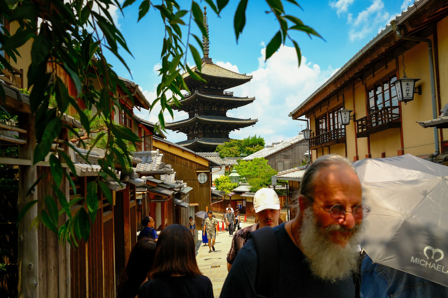 人们在历史街道上走，背景是一个宝塔