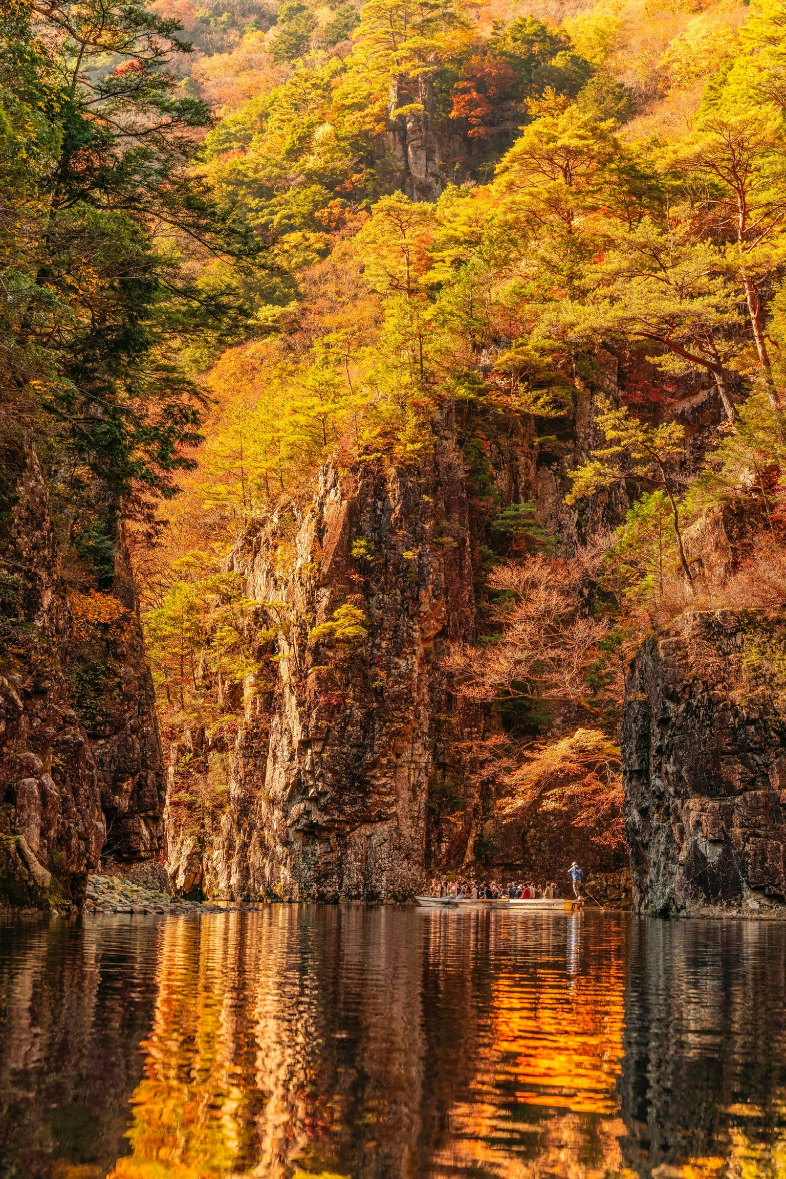 秋の色彩に包まれた岩と水面の反射が美しい風景