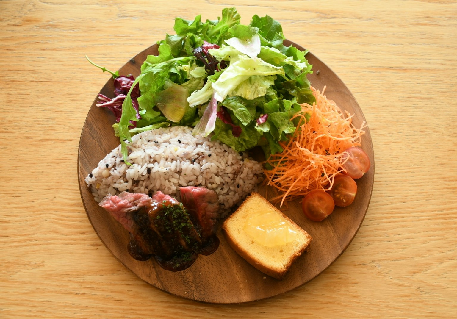 A plate featuring colorful salad, rice, and various side dishes