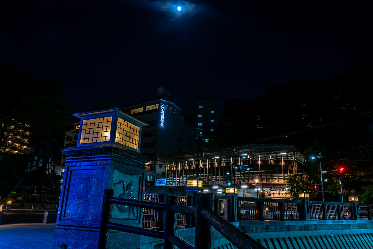 ทิวทัศน์เมืองยามค่ำคืนที่มีสะพานและอาคารสีน้ำเงิน