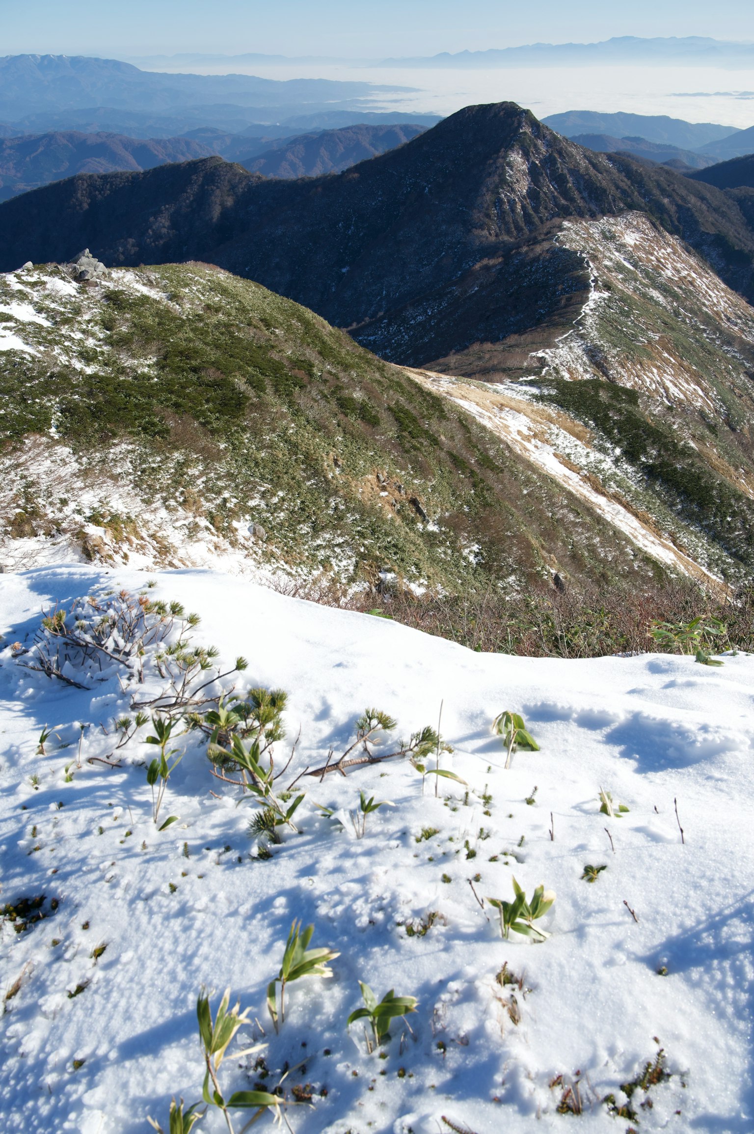 Paisaje montañoso cubierto de nieve con picos distantes