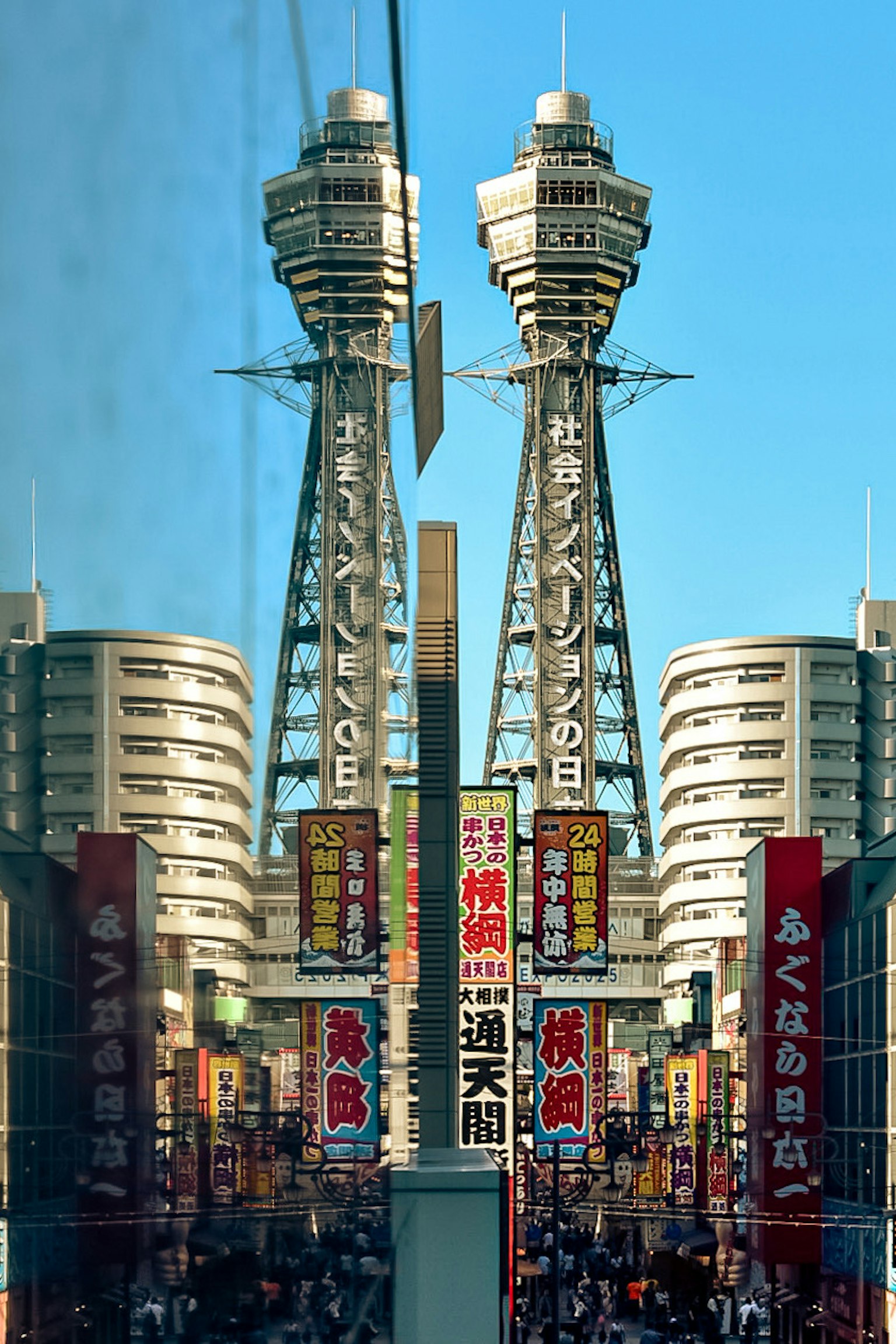 La torre Tsutenkaku di Osaka si riflette in una scena urbana vivace con insegne colorate