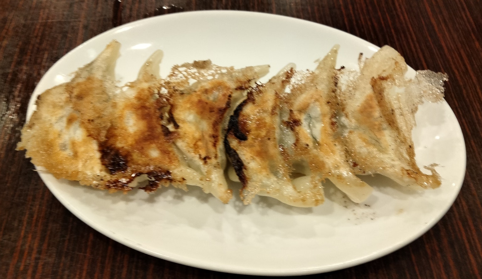 Piatto di cinque ravioli fritti croccanti disposti ordinatamente