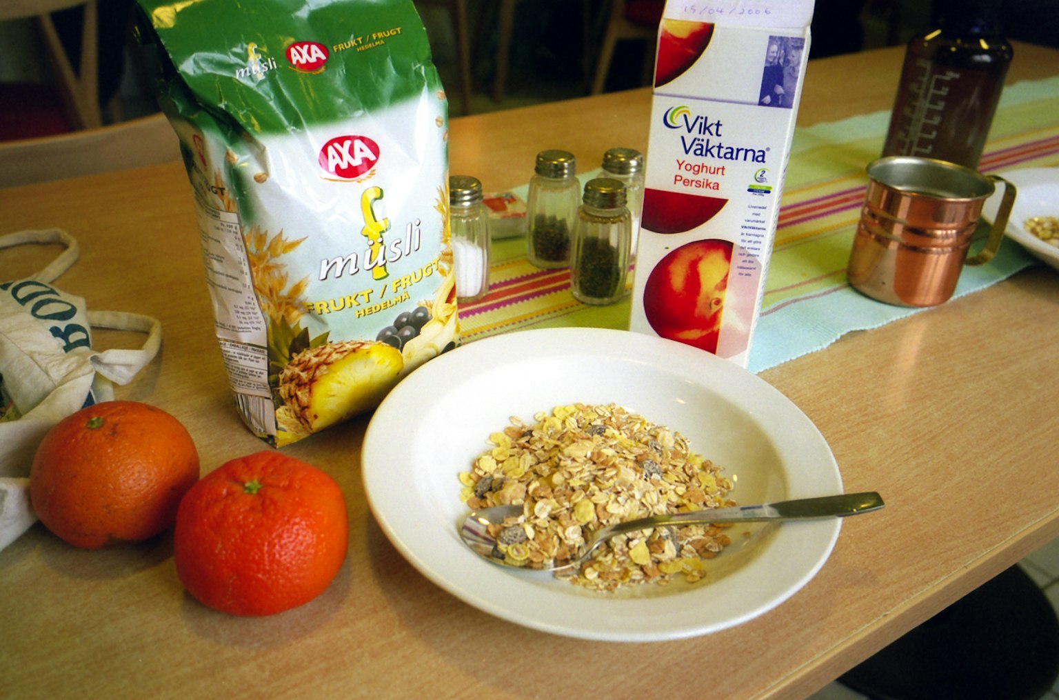 早餐桌上有麦片、橙子和牛奶