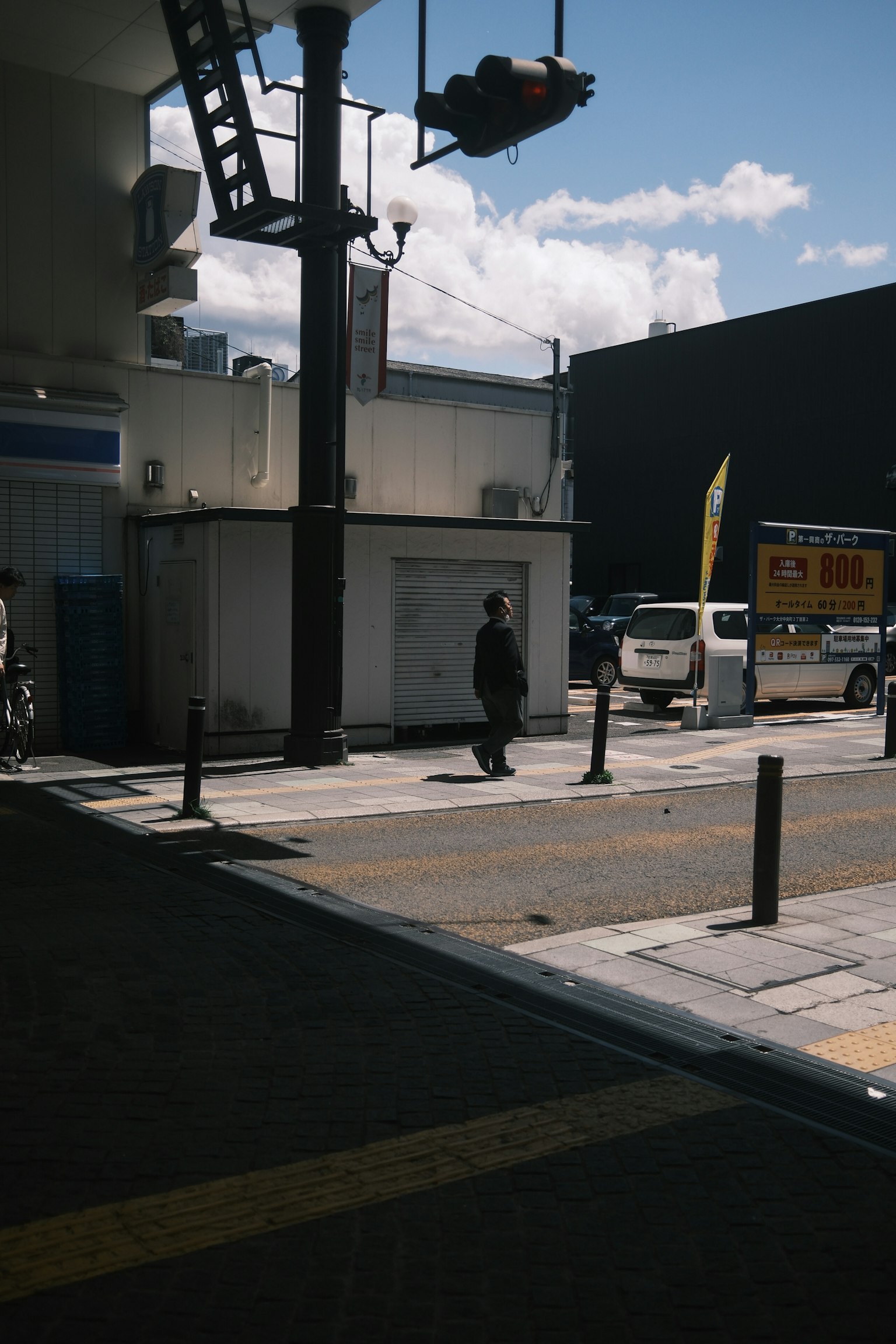 青空の下で歩く人と周囲の建物が見える街の風景