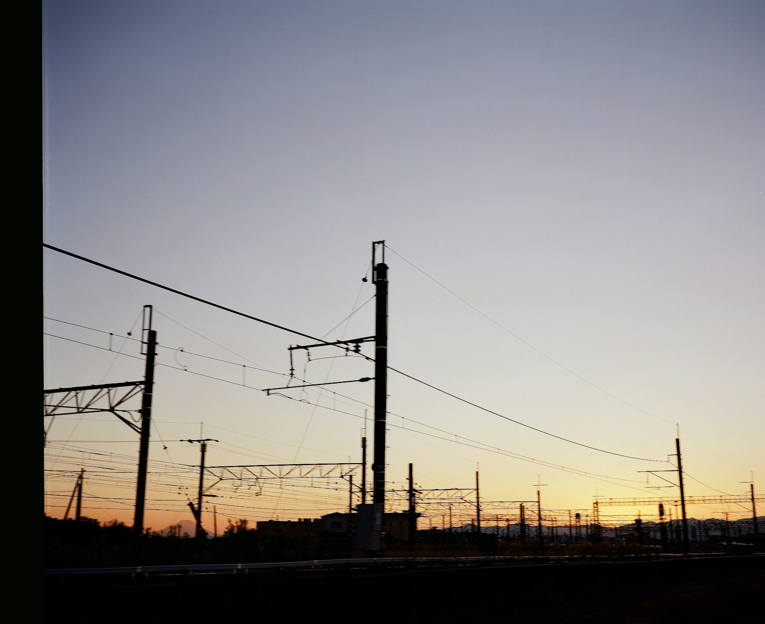 日落天空下的鐵路電杆輪廓