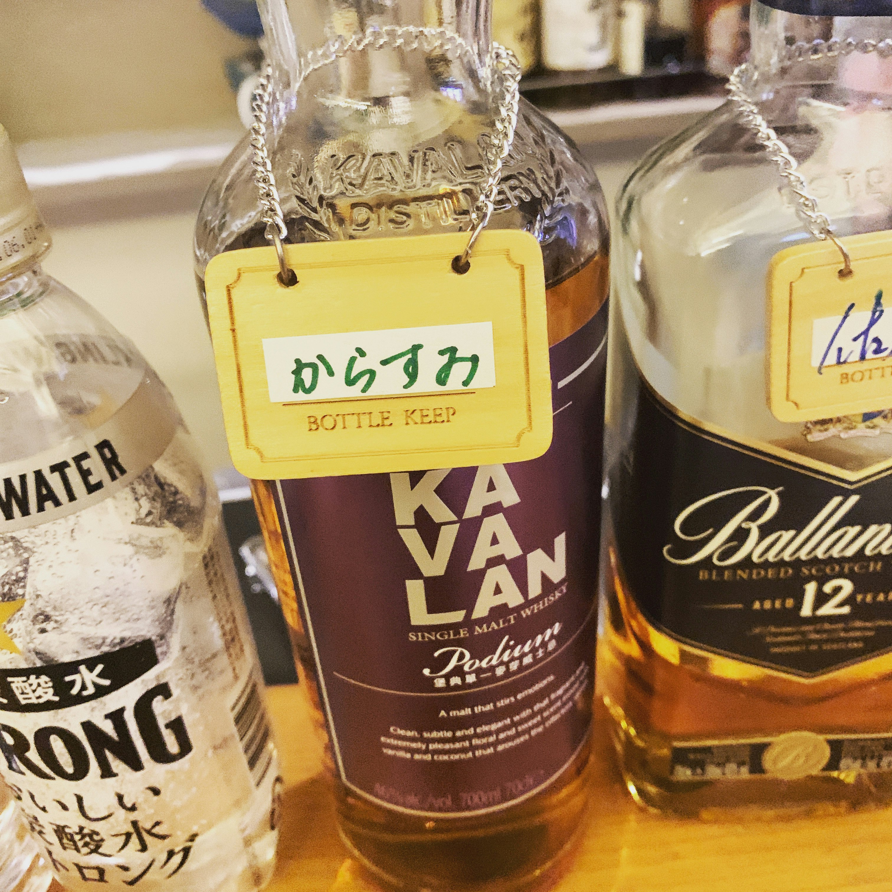 ラベル付きのボトル飲料が並ぶ棚のクローズアップ