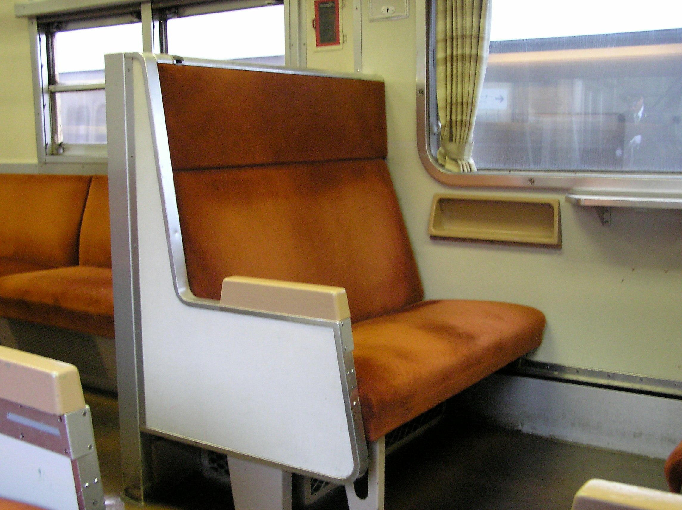 車内のベンチシートと窓のある鉄道車両の内装