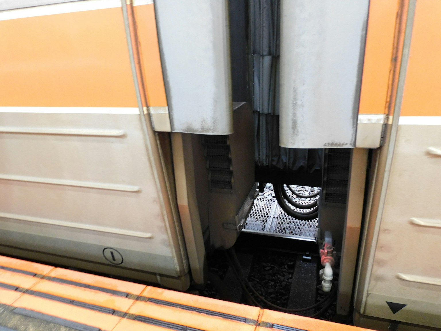 Spalt zwischen den Waggons des Zuges mit Verkabelung und Bahnsteig