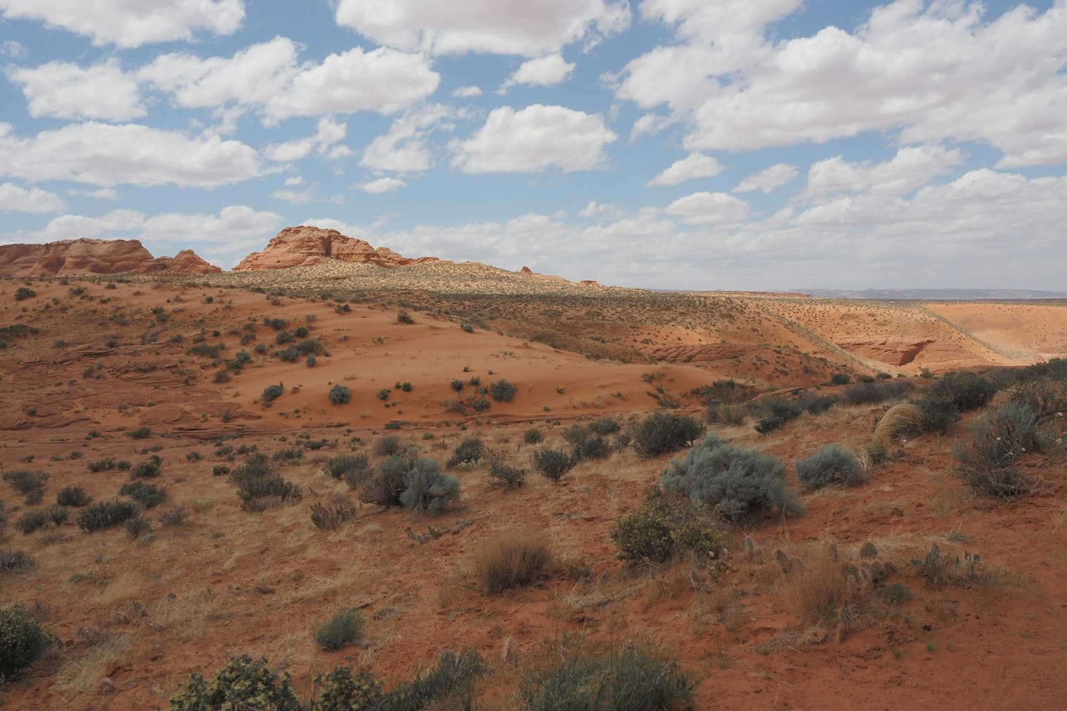 Dunes de sable rouge avec ciel bleu et nuages blancs