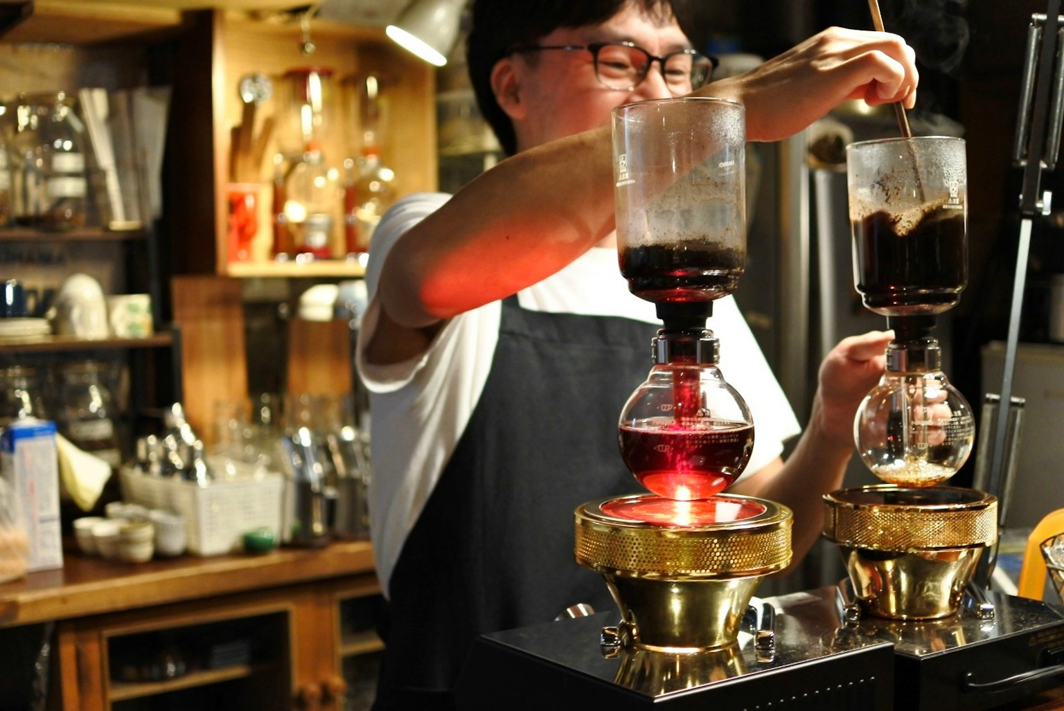 Barista menyeduh kopi menggunakan siphon