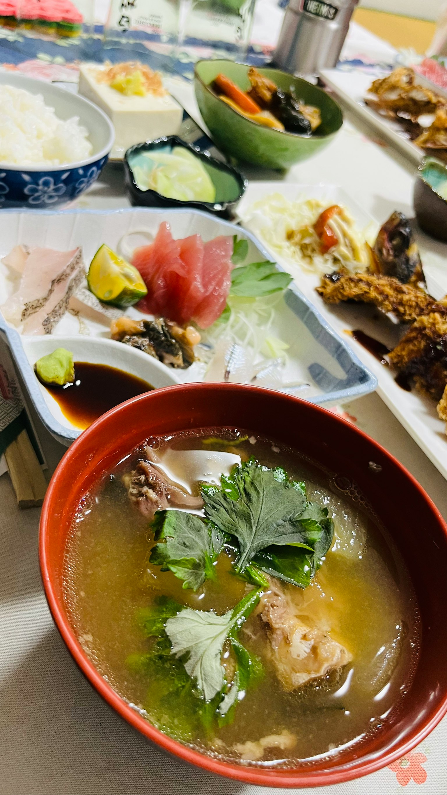 桌子上摆放着色彩缤纷的日本菜肴，包括味噌汤和刺身拼盘
