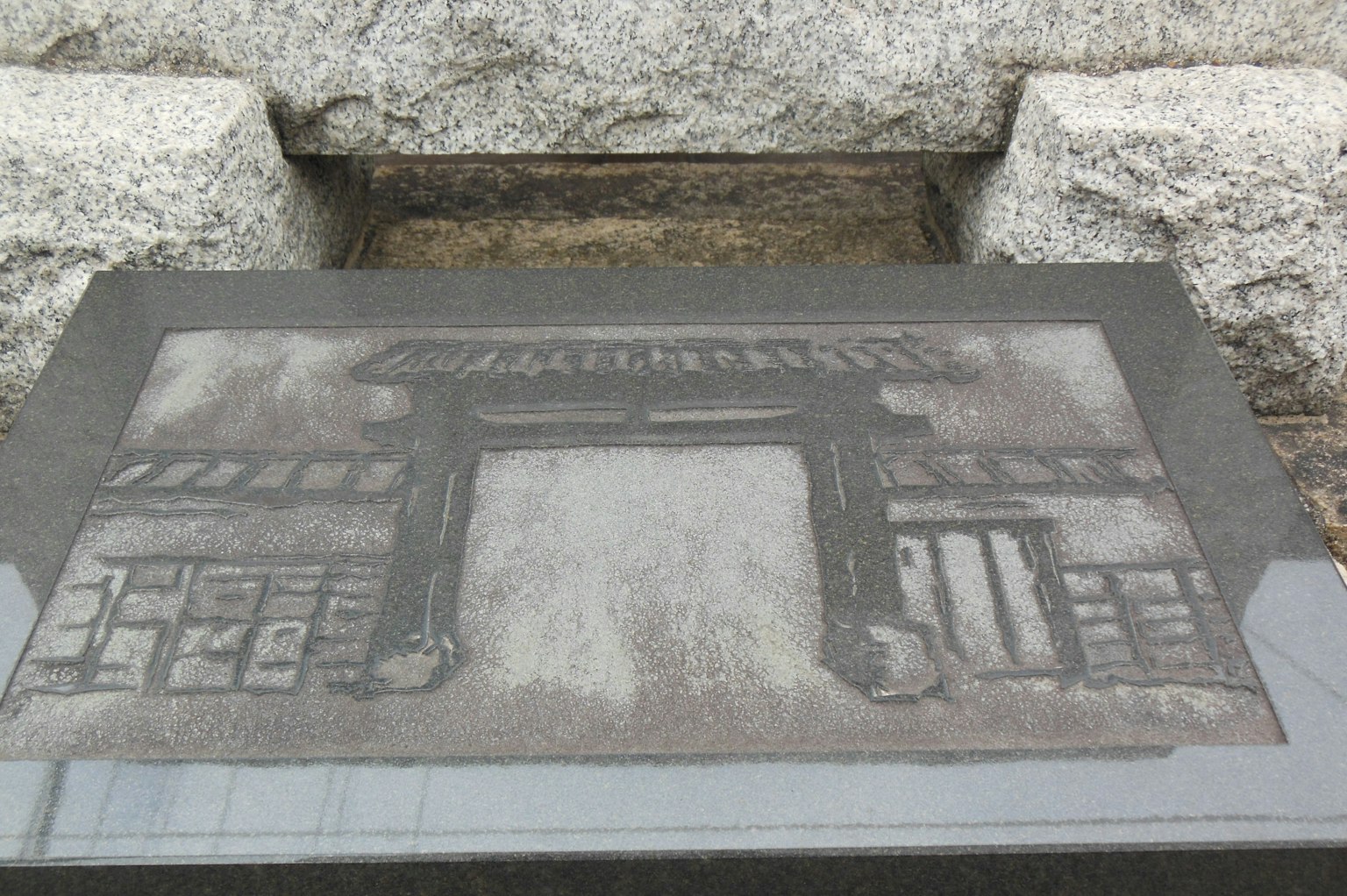 Stone plate featuring an illustration of an ancient gate