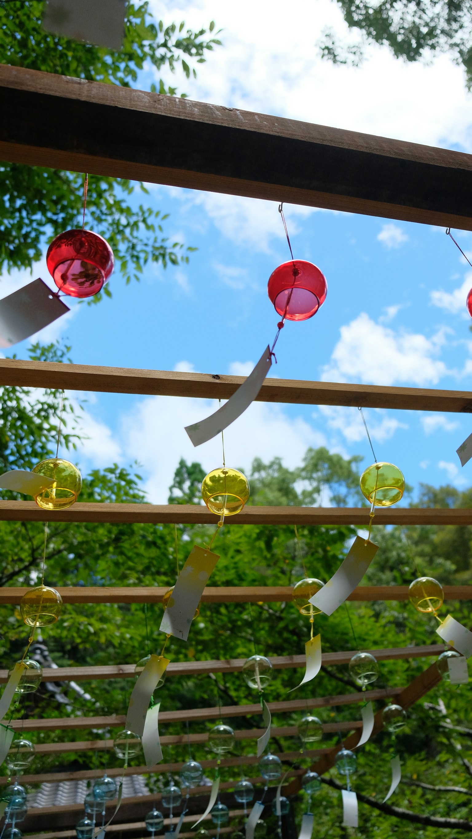 Decorazioni colorate in rosso e giallo appese sotto un cielo blu con strisce bianche