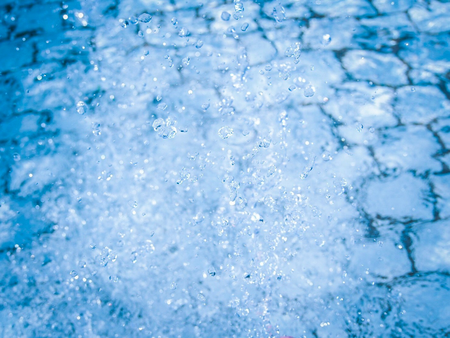 superficie de agua azul con burbujas espumosas y salpicaduras