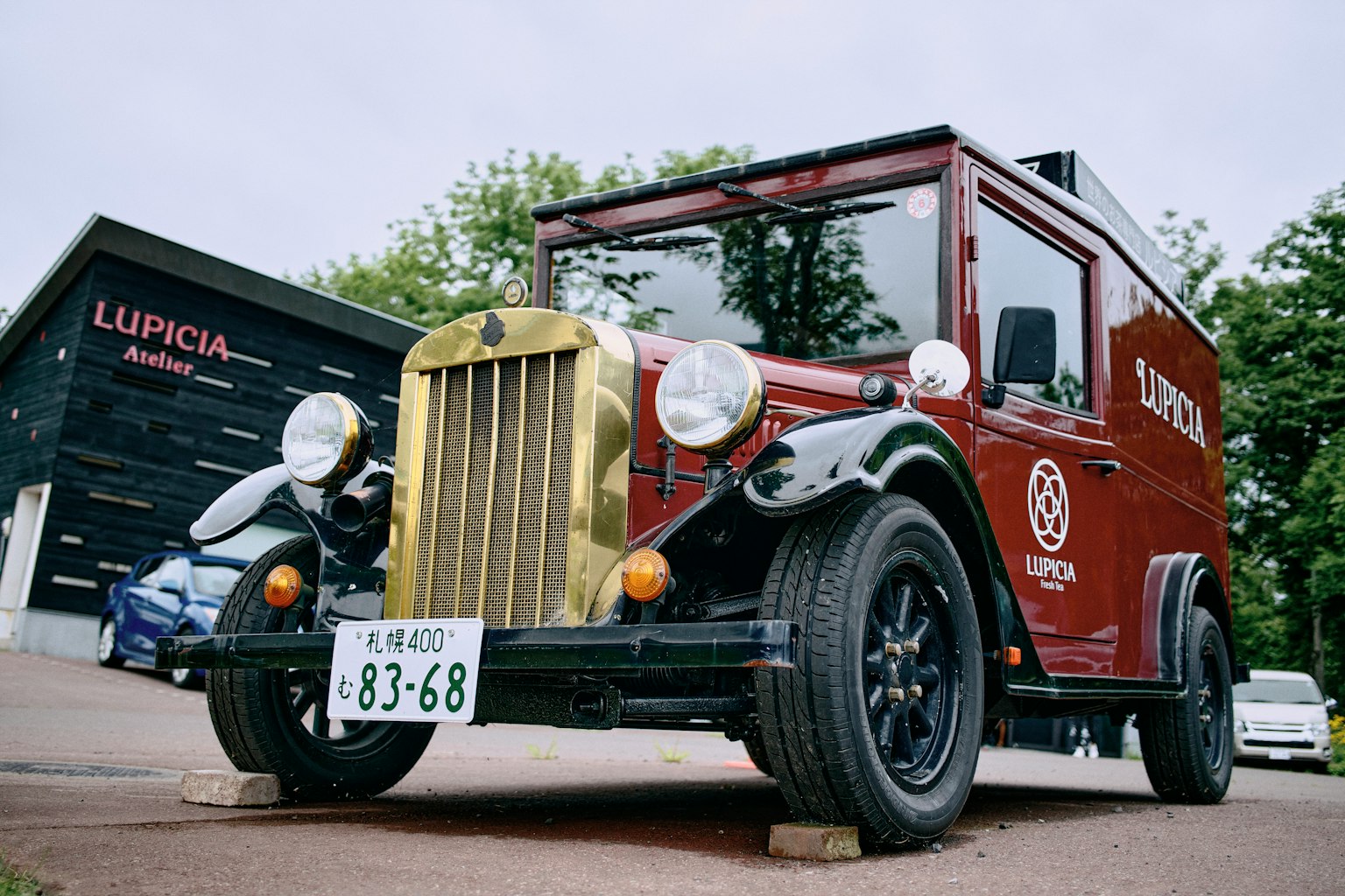 Vintage roter Lastwagen mit goldener Kühlergrill und weißen Reifen modernes Gebäude im Hintergrund
