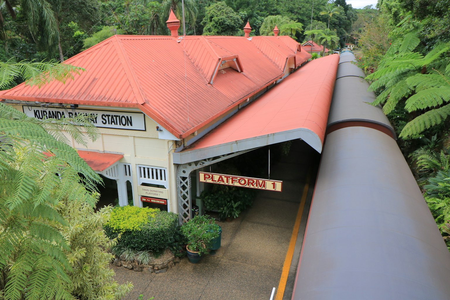 Katoomba Station with a red roof surrounded by lush greenery and a covered platform