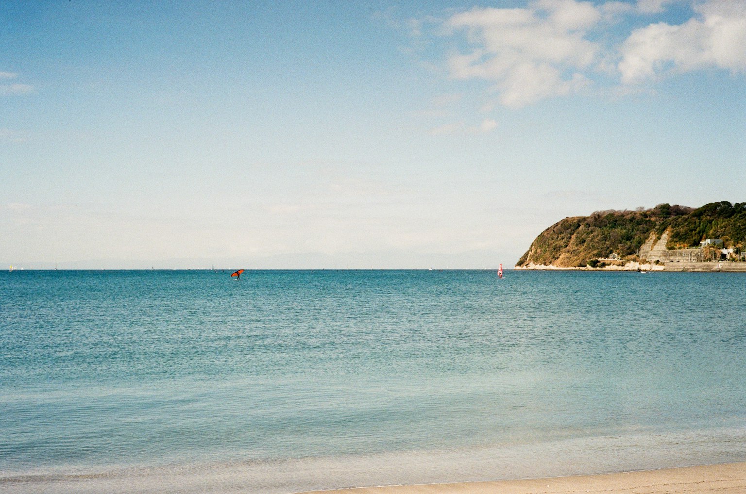 Scène de plage sereine avec mer calme et ciel bleu clair