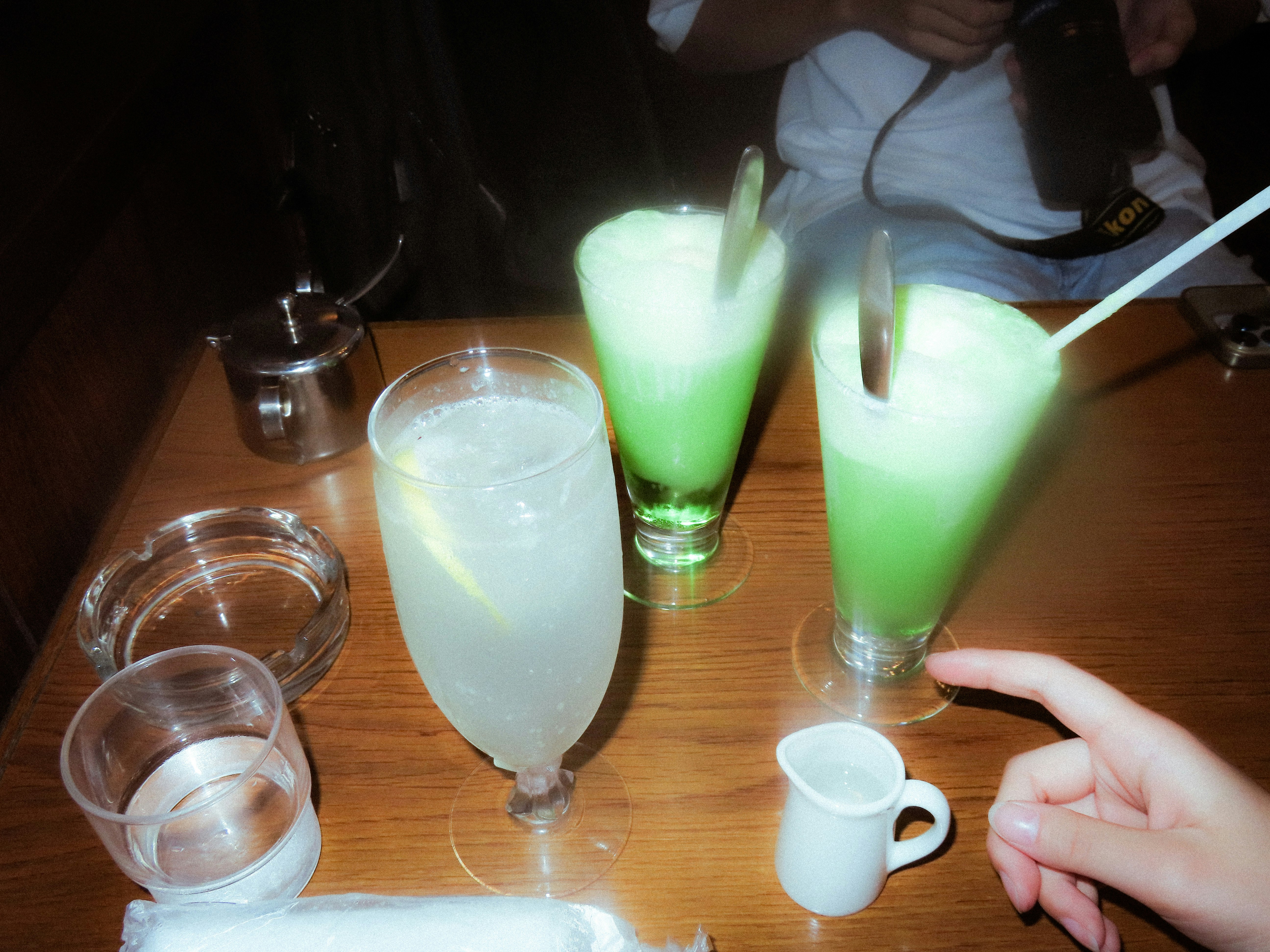 グラスに注がれたクリームソーダと炭酸ドリンクのあるカフェのテーブル