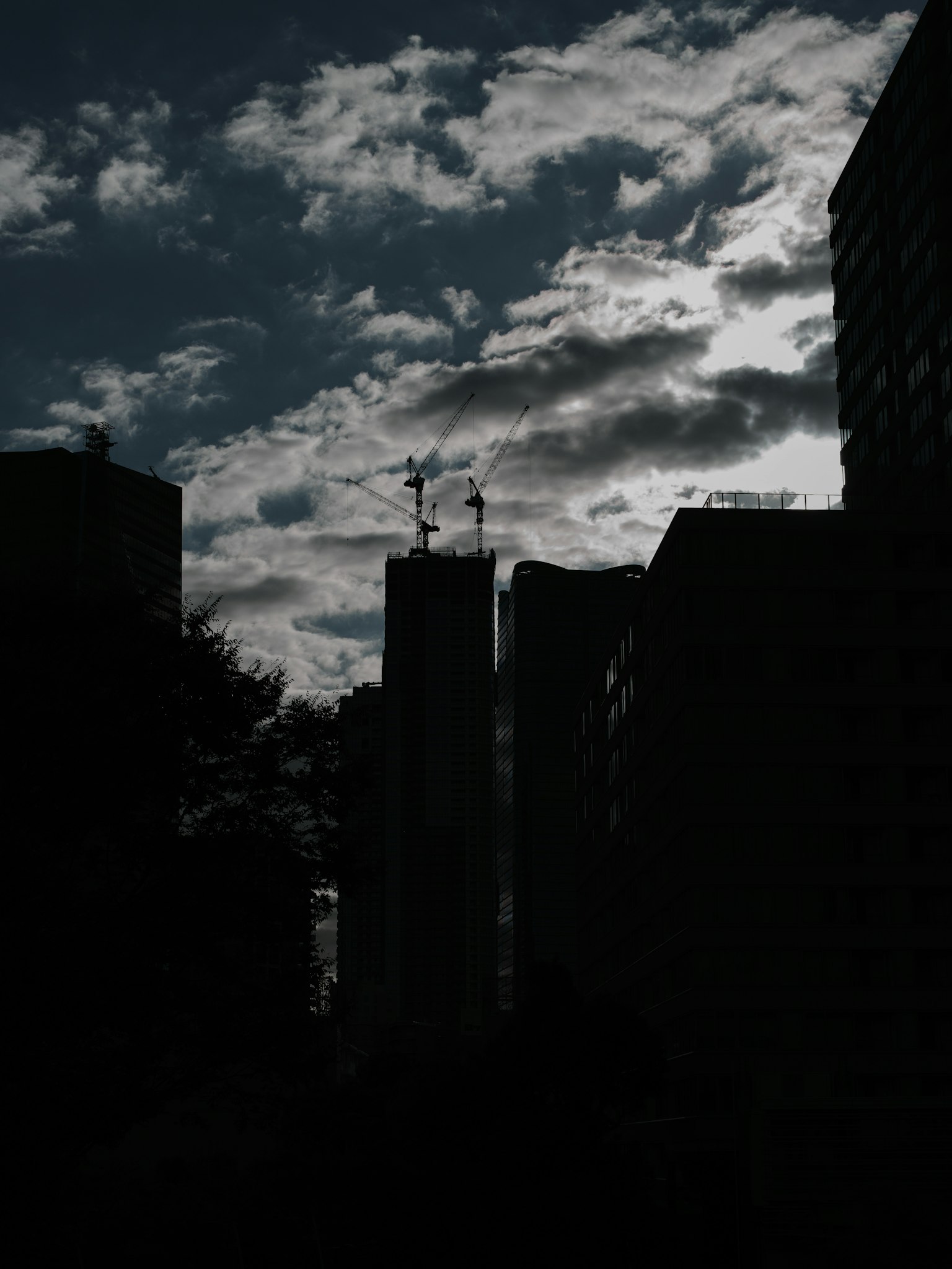 Dark silhouette of buildings against a cloudy sky