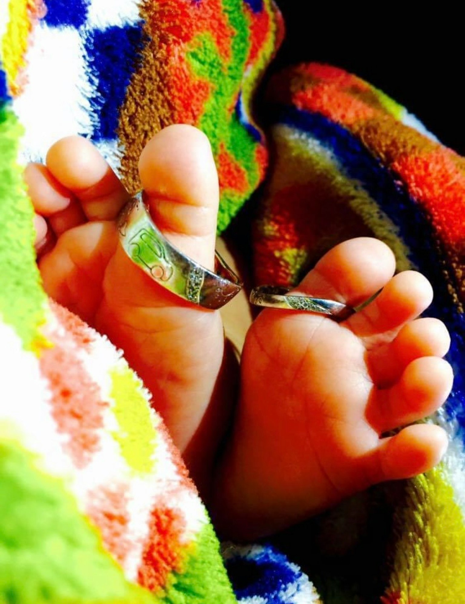 Kaki bayi dibungkus dalam selimut berwarna-warni dengan cincin