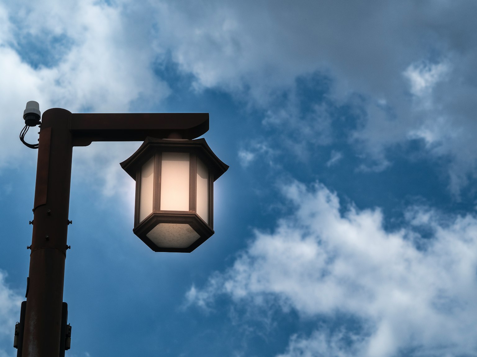 Une lanterne brillante contre un ciel bleu avec des nuages blancs