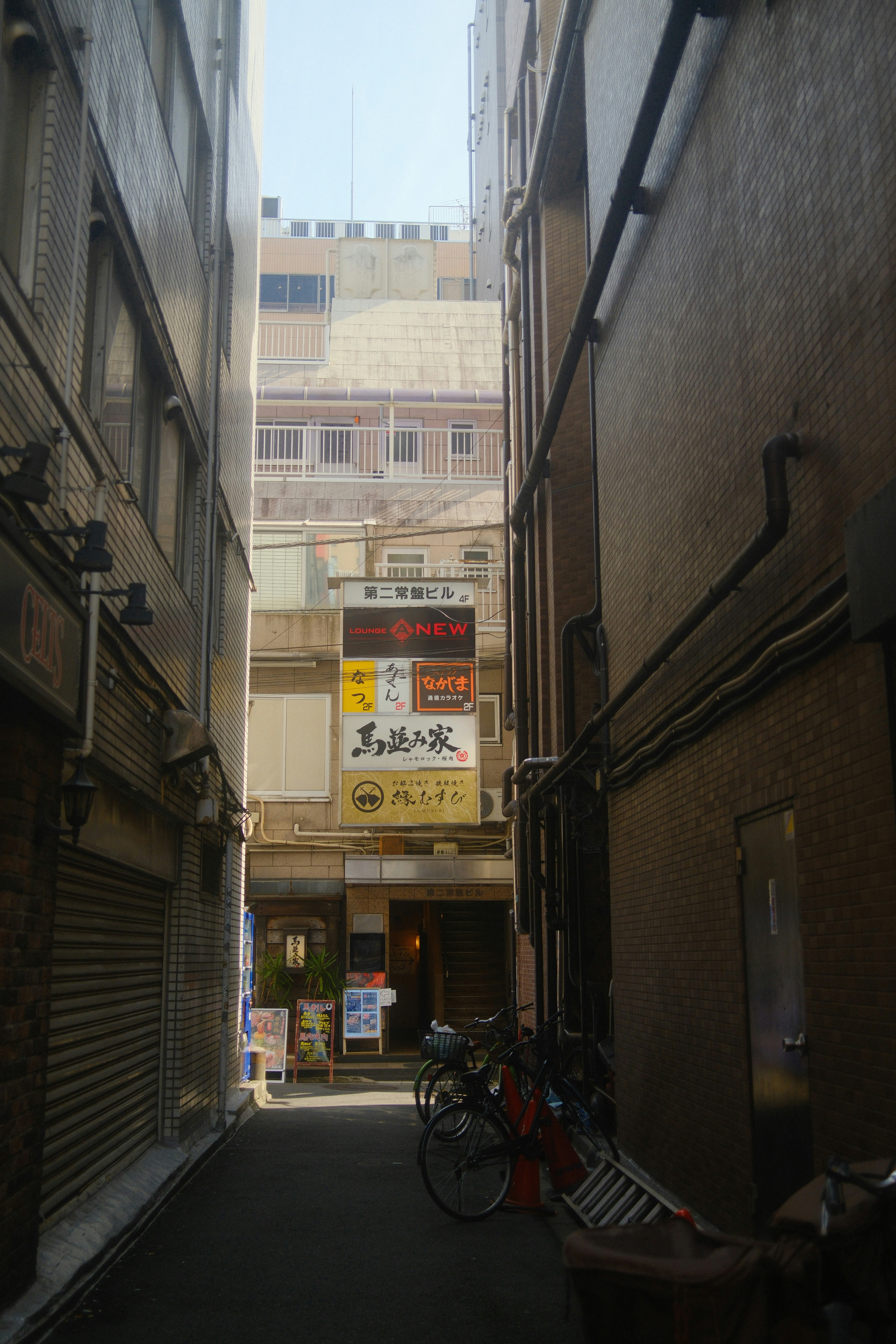 路地の自転車と看板が並ぶ商店街の軒先