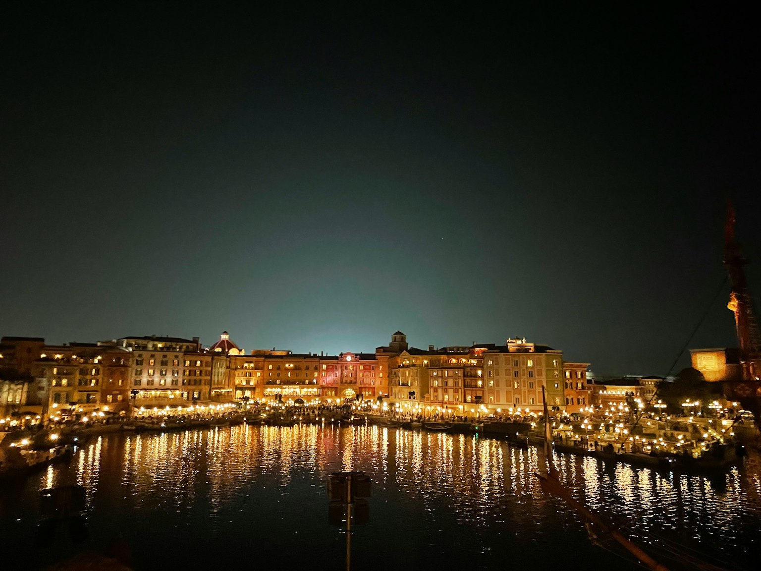 Hermosa vista nocturna de una ciudad portuaria con luces reflejándose en el agua