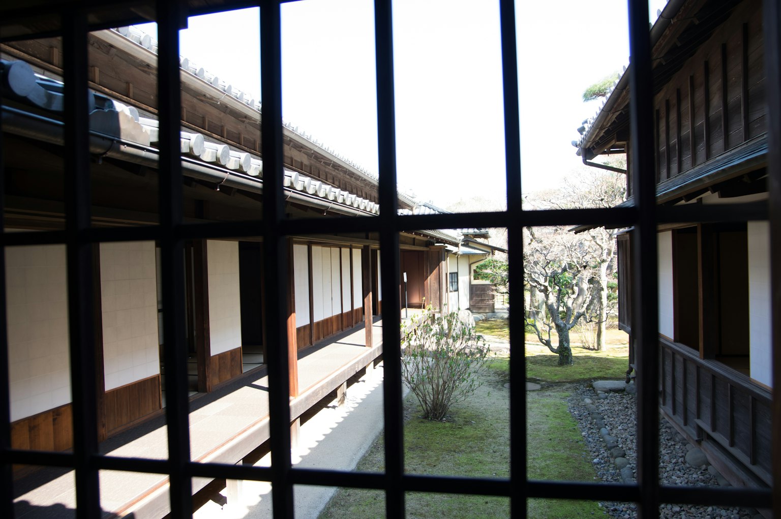 Blick auf traditionelle japanische Architektur mit Innenhof durch Fensterstäbe
