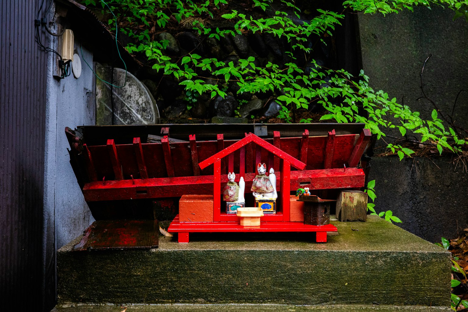 Un pequeño altar rojo rodeado de follaje verde