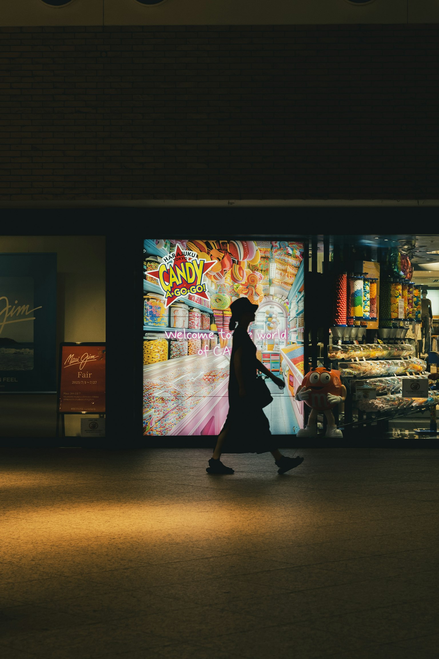 人影が通り過ぎるカラフルな店の前の風景