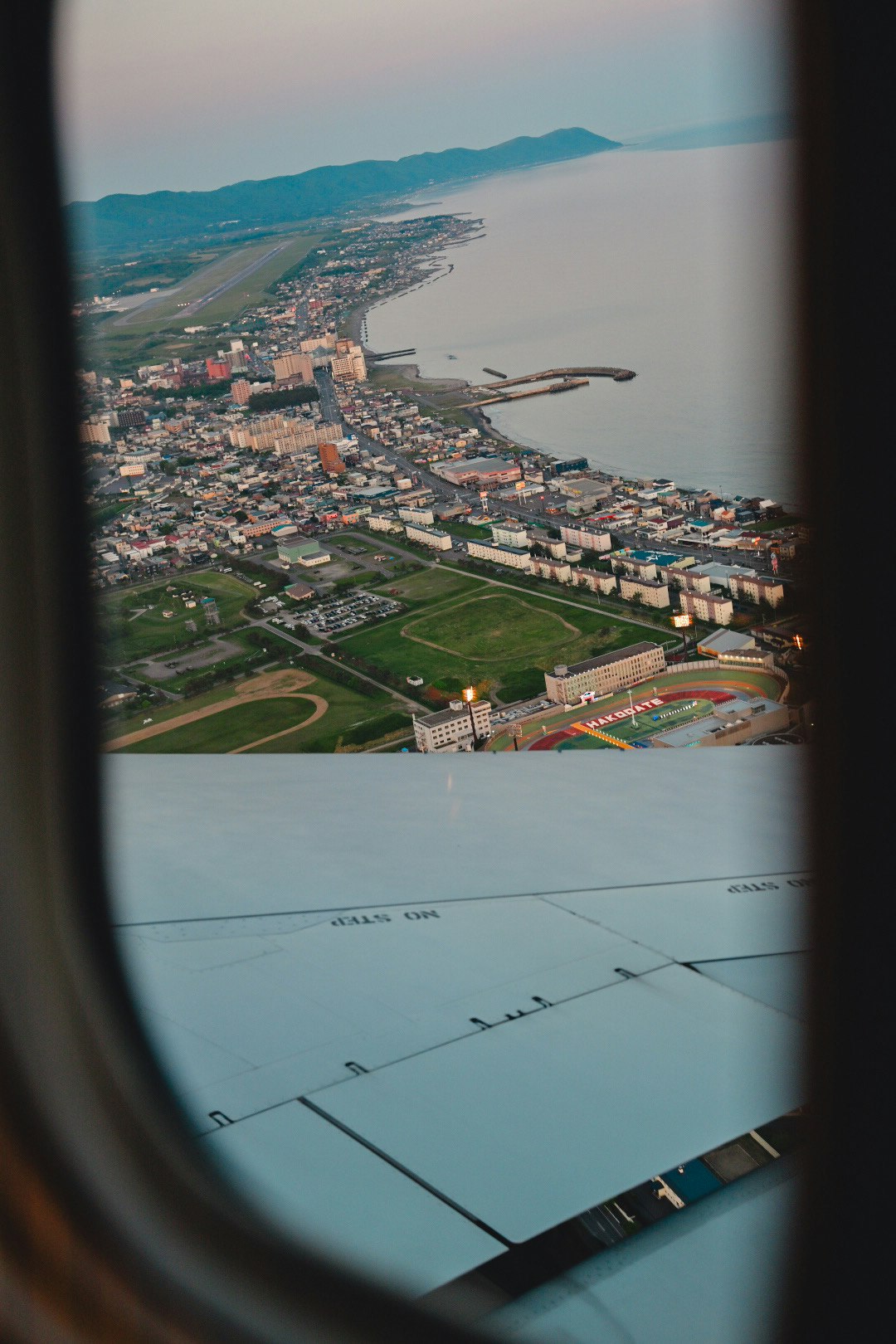 Vista di una città costiera e di una baia dal finestrino dell’aereo