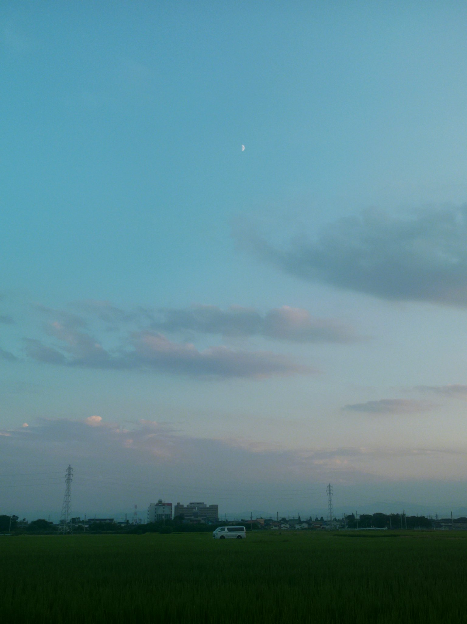 寧靜的風景，藍天與雲彩，稻田上方有一輪小月亮