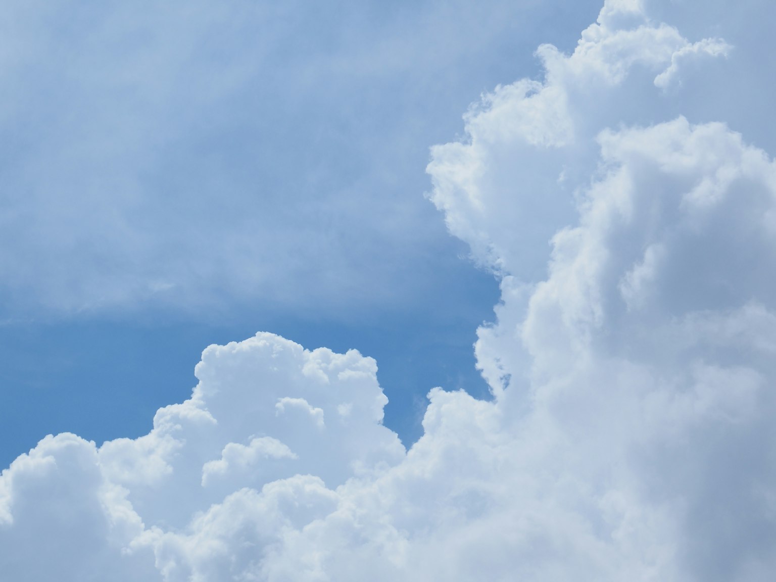 Fluffy white clouds against a clear blue sky