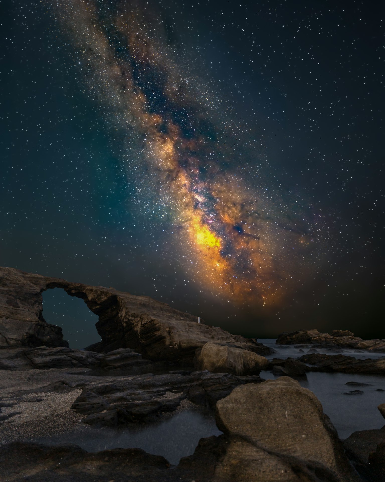 Stupendo paesaggio con la Via Lattea e un arco di roccia sotto un cielo stellato