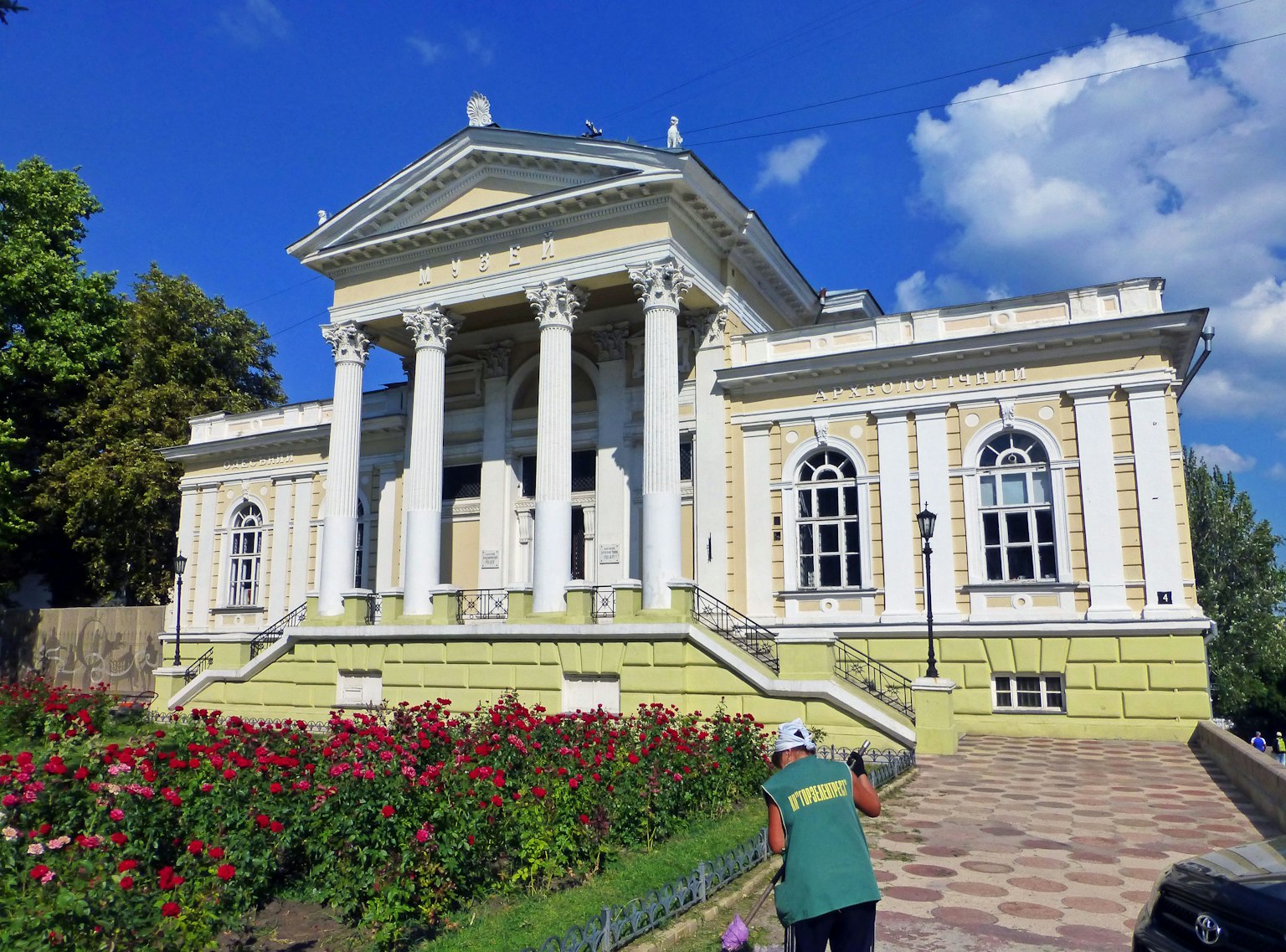 Bâtiment historique avec des colonnes entouré d'un jardin coloré