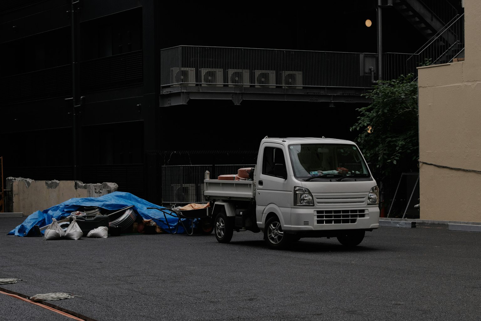 White truck passing by blue tarp in urban setting