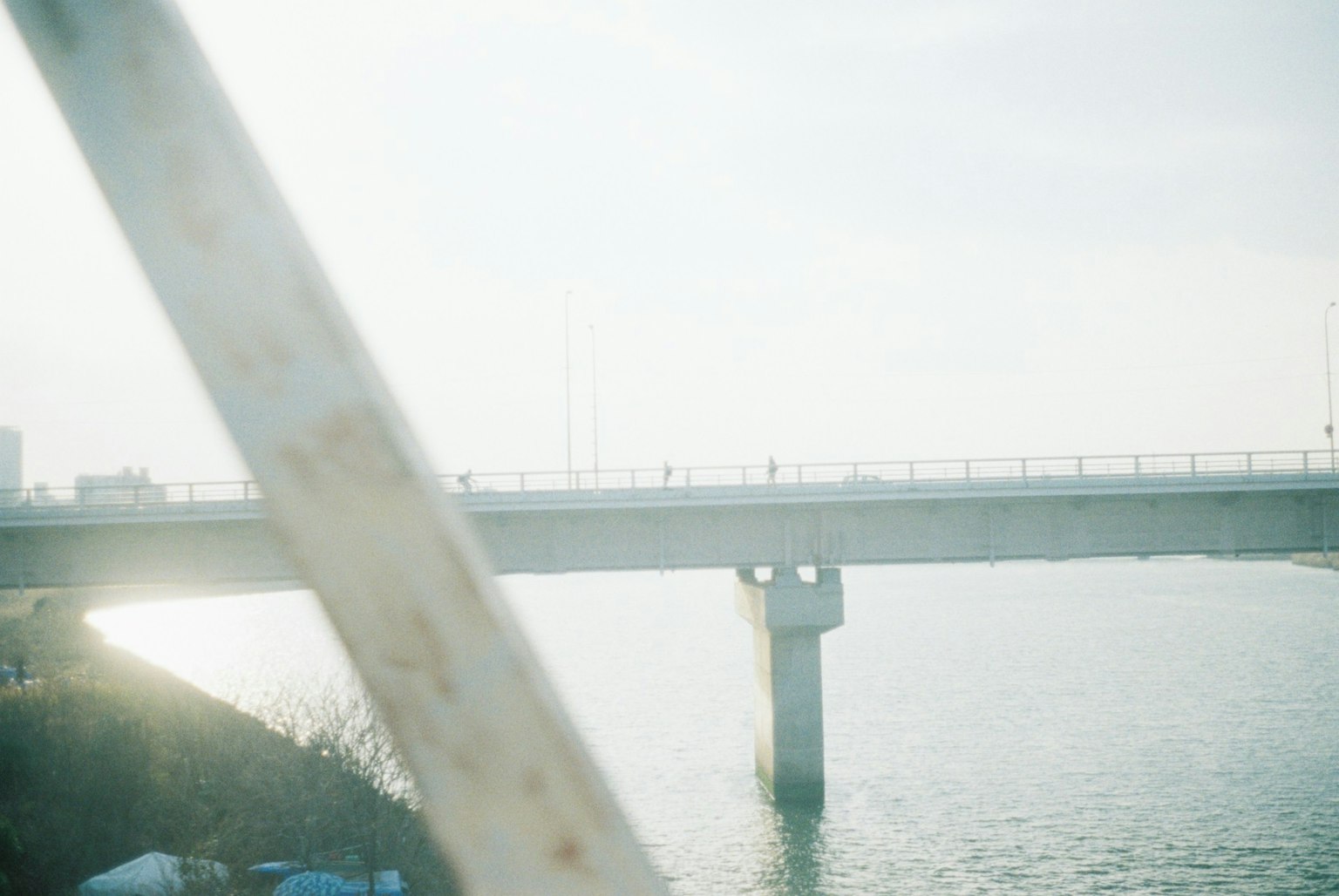 Una foto que presenta un puente sobre un río con luz suave