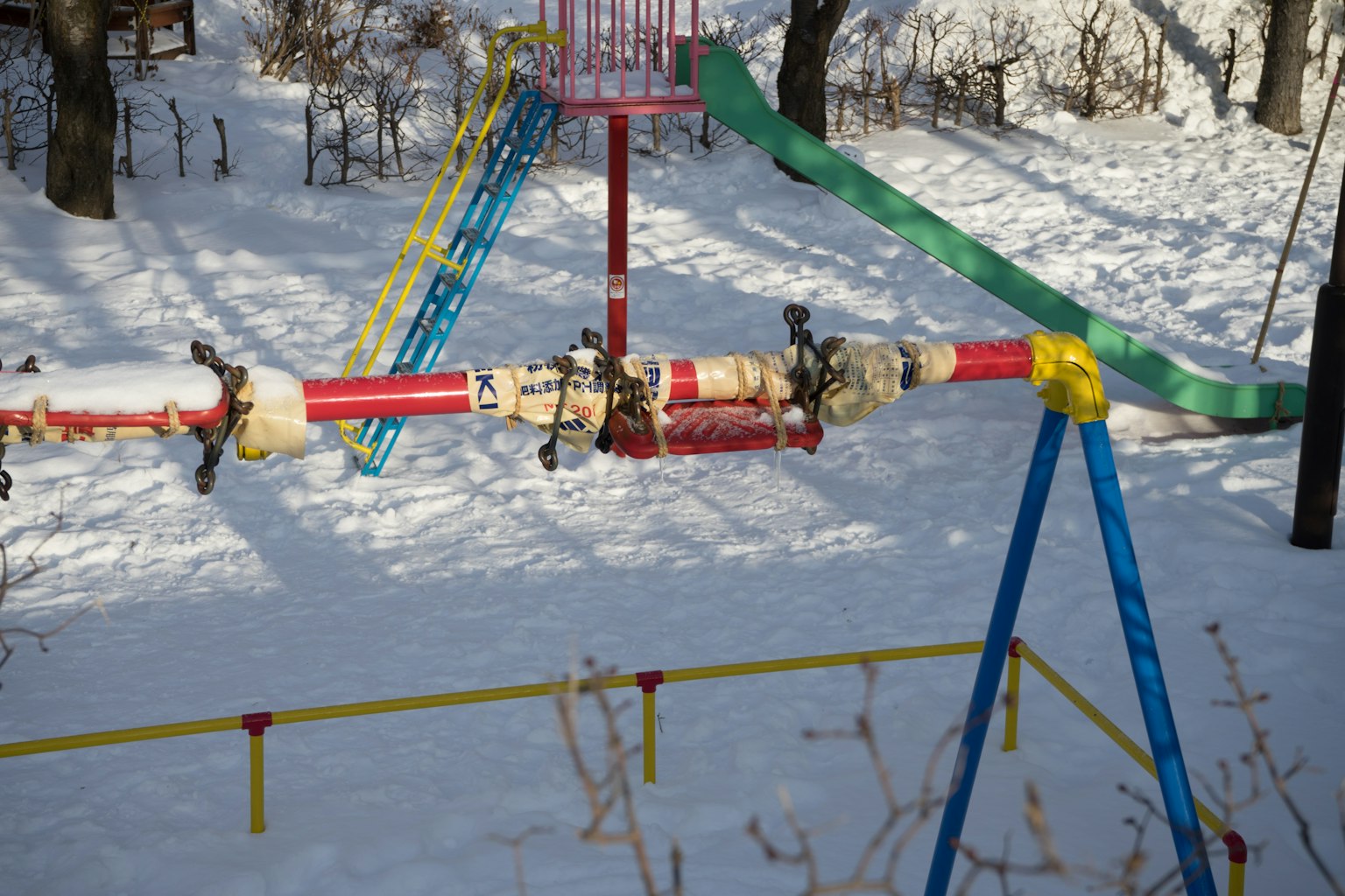 Equipo de parque infantil cubierto de nieve con tobogán colorido
