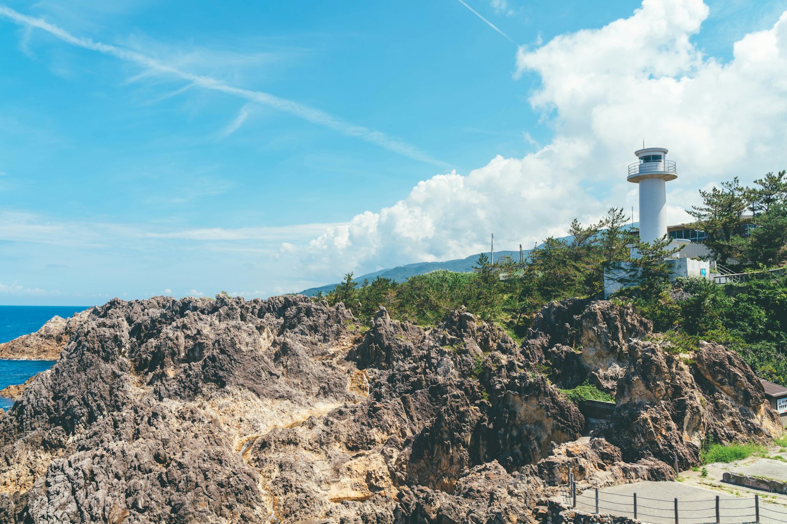 蓝天之下的岩石海岸和灯塔的风景