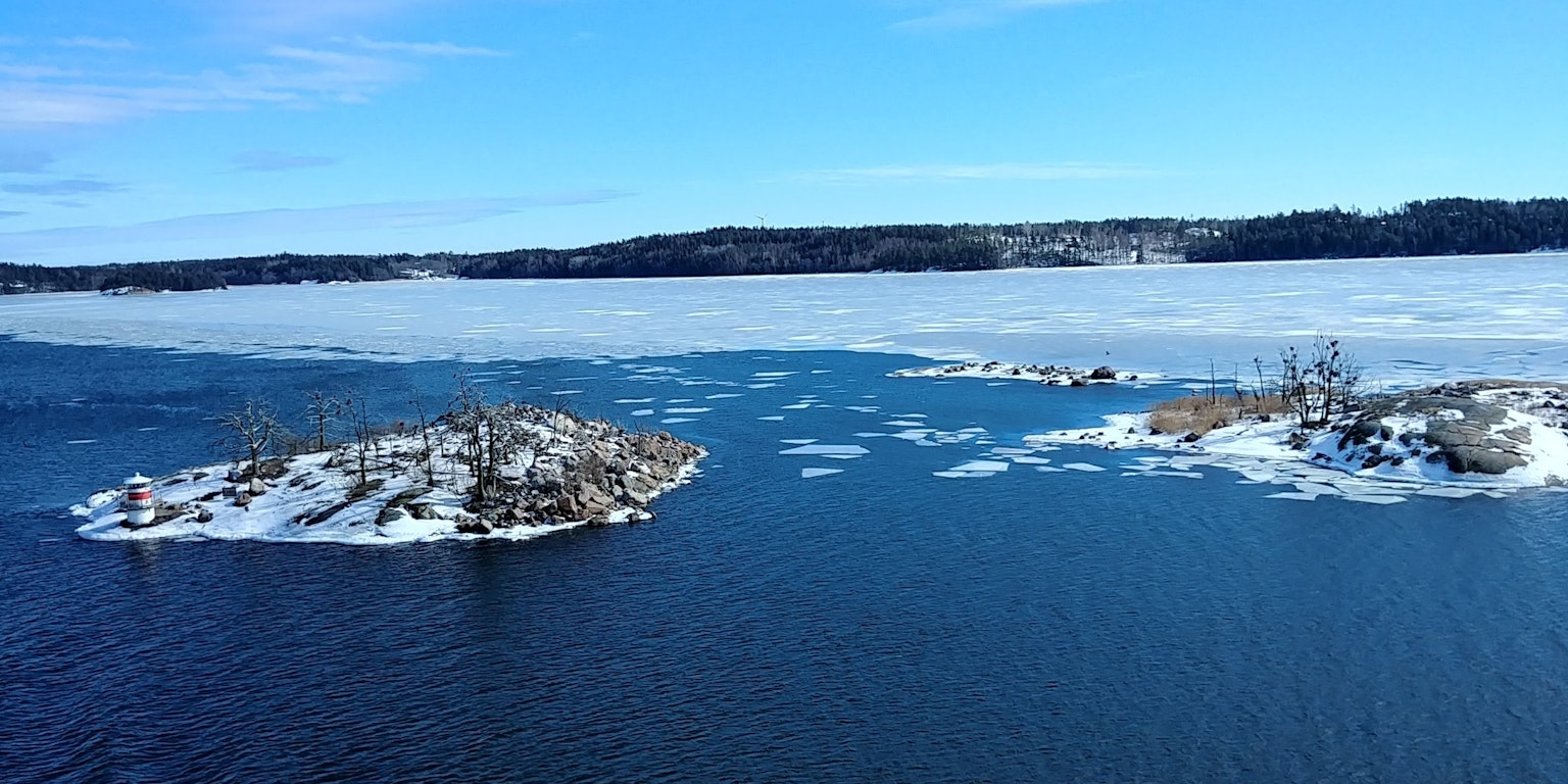 Small islands and ice fragments on a winter lake under a blue sky