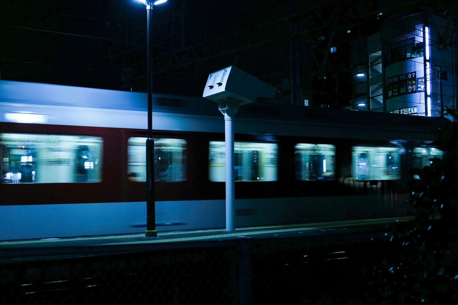 Kereta bergerak di stasiun malam dengan lampu terang