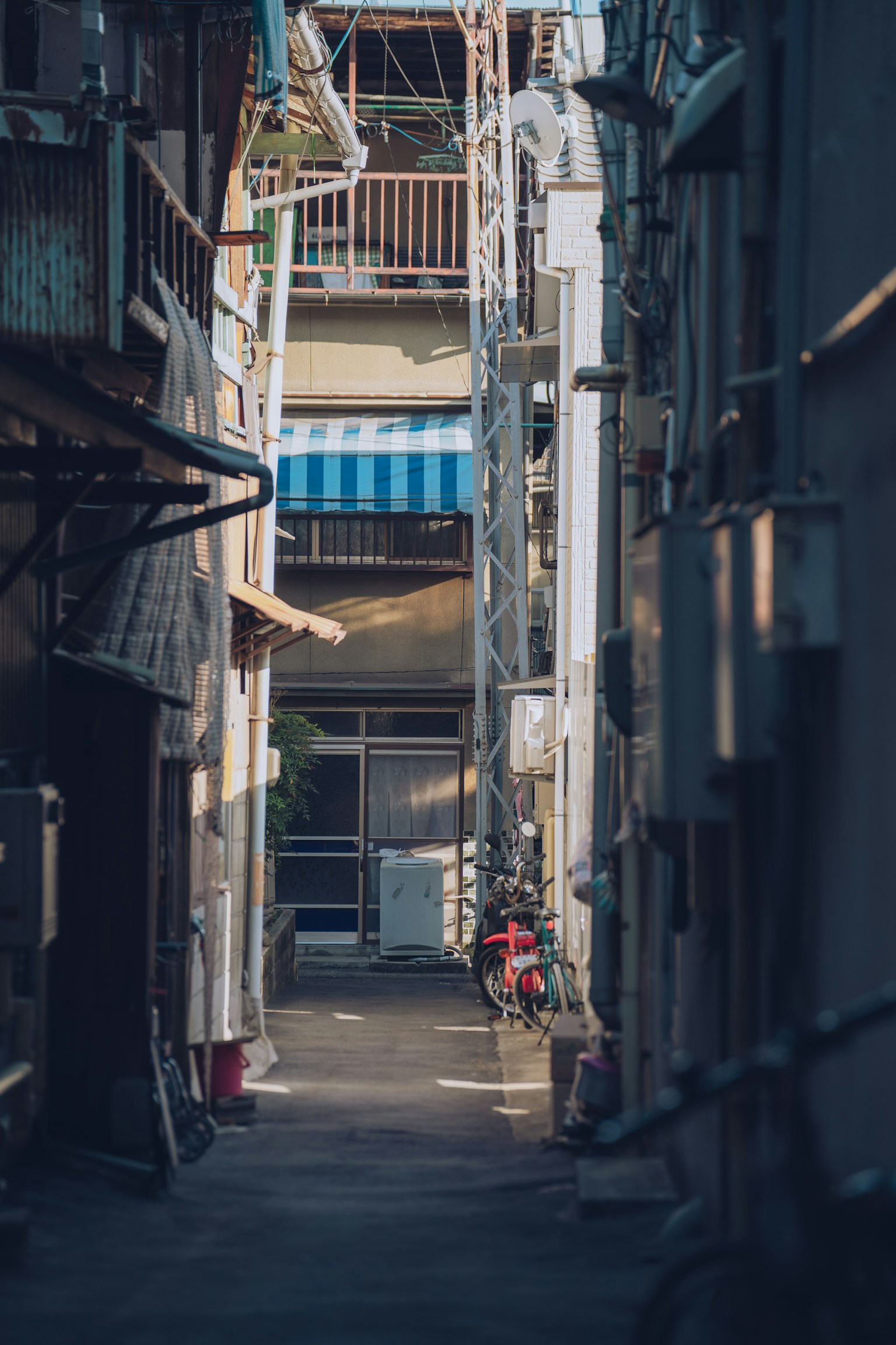 Narrow alley with buildings and a blue striped awning