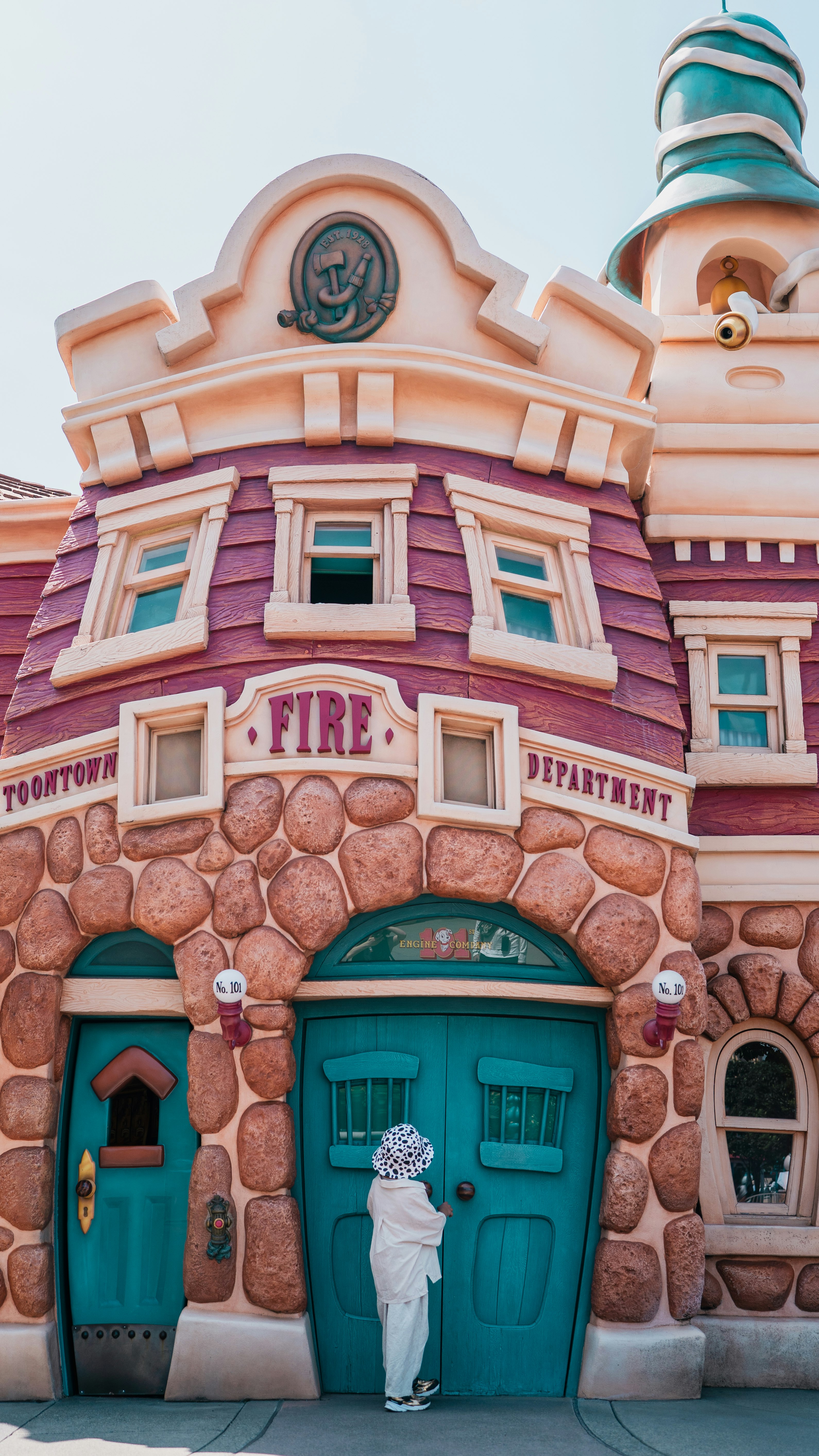 ディズニーの消防署風の建物と門の前の人物