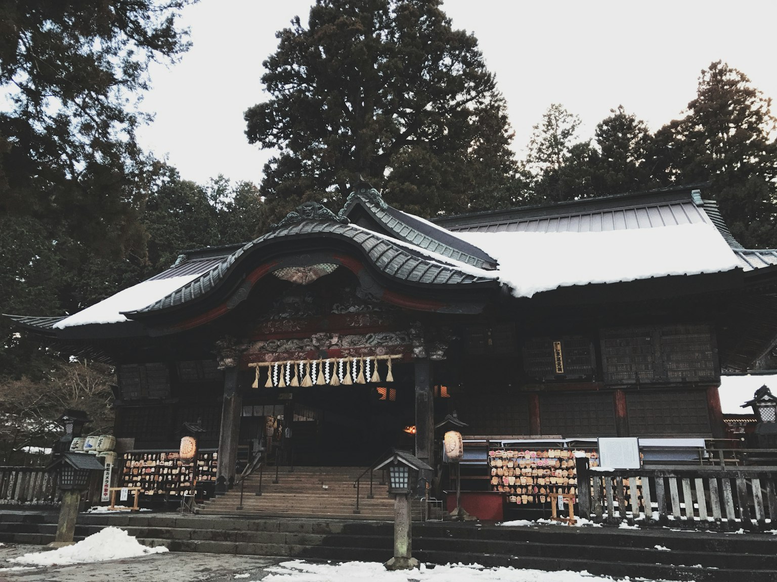 被雪覆蓋的傳統日本神社建築和周圍的樹木