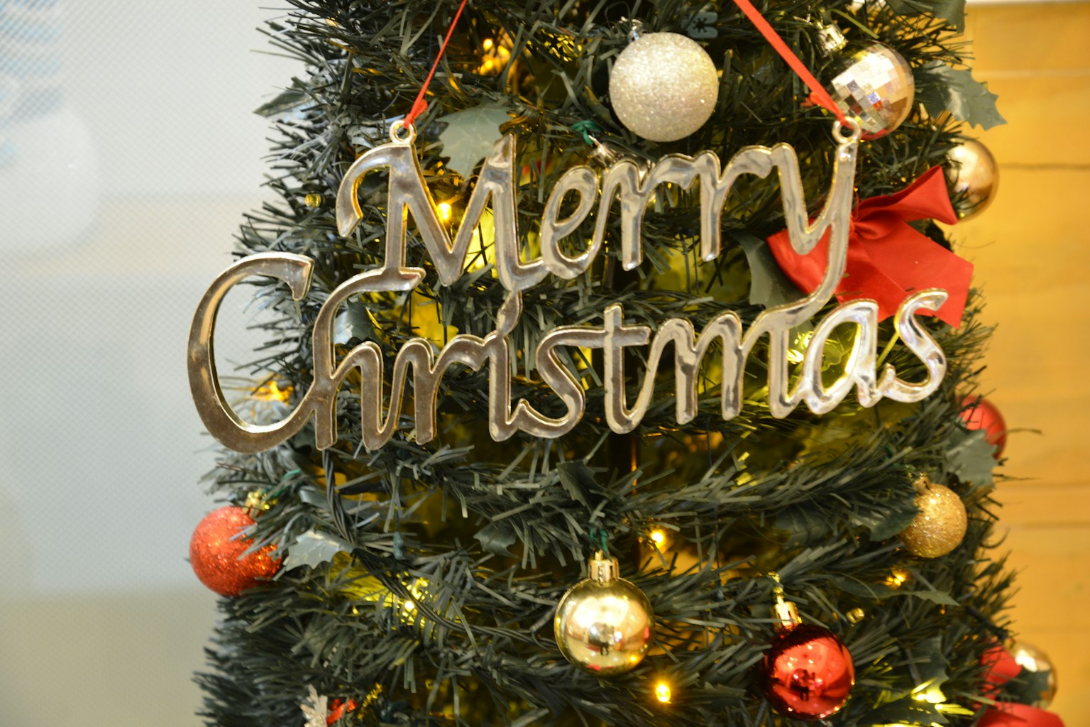 Pohon Natal dihiasi dengan tanda Selamat Natal dan ornamen dekoratif