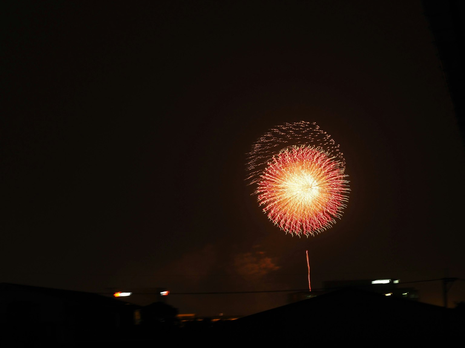 Spectacle de feux d'artifice colorés dans le ciel nocturne avec un motif circulaire et un centre lumineux