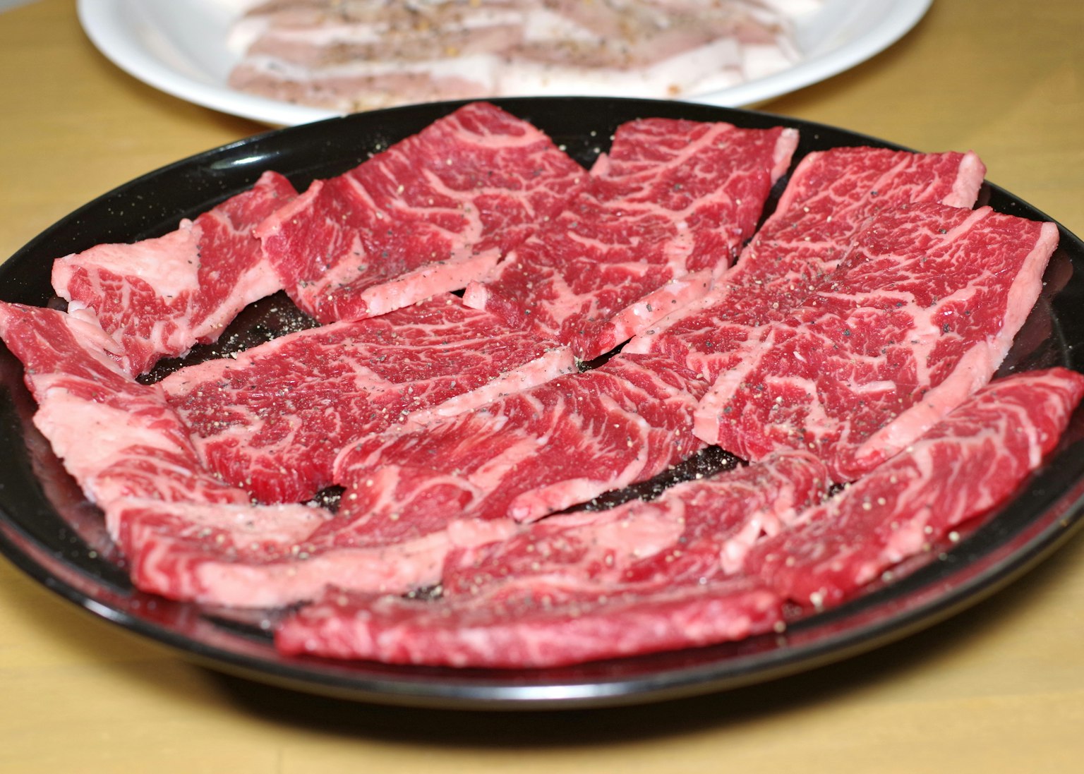 Daging wagyu marmer yang indah disusun di atas piring